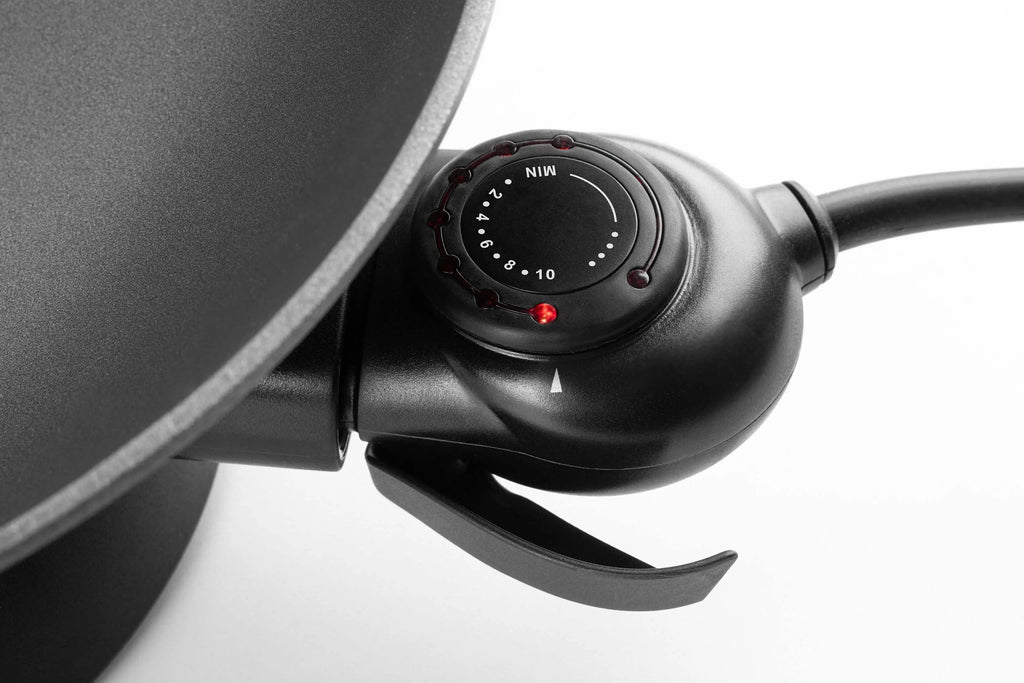 Schwarze elektrische Pfanne mit Knopf für die Temperaturregelung.